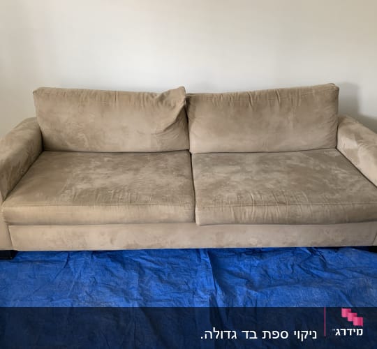 ספה חומה על יריעת בד כחולה לניקוי